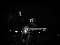 black and white photo of a man playing an acoustic guitar