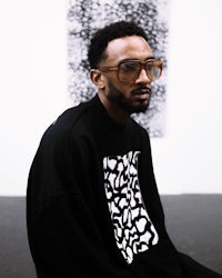 a man wearing glasses and a black sweatshirt