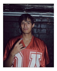 a young man in a red jersey posing for a picture