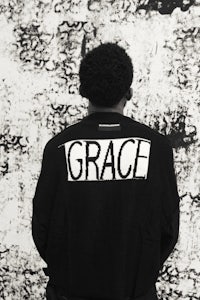 a man wearing a jacket with the word grace on it