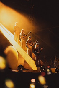 a group of people standing on a stage in front of an orange light