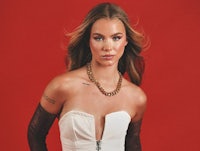 a woman in a white dress posing on a red background