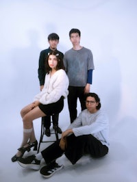 a group of people posing in front of a white background