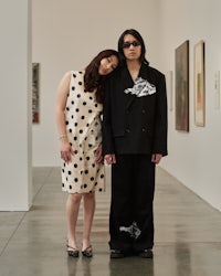 a man and woman posing for a picture in an art gallery