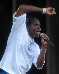 a man in a white shirt singing into a microphone