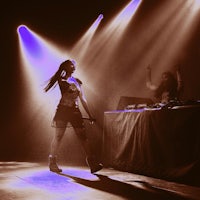 a woman is dancing on stage in front of spotlights