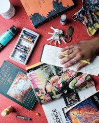 a person is laying out art supplies on a red table