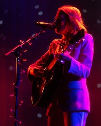 a woman in a suit singing into a microphone