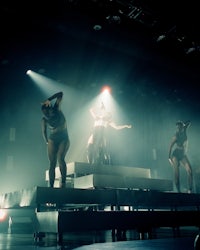 a group of dancers on stage in the dark