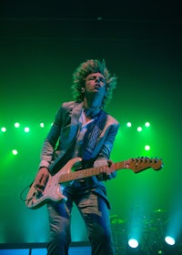 a man playing a guitar on stage