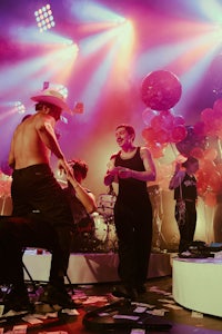 a group of people on stage with balloons in the background