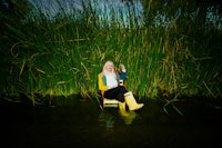 a woman sitting on a chair in the water