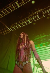 a woman with dreadlocks on stage at a concert