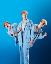 three men in blue suits standing on a blue background