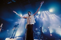 a man on stage with his arms outstretched