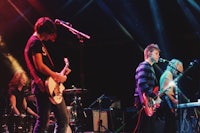 a group of people on stage with guitars and microphones