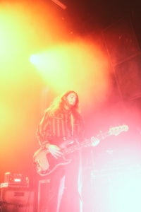 a man playing a guitar in front of a bright light