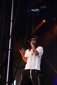 a man with dreadlocks singing into a microphone