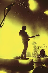 a group of people standing on stage in front of a yellow light