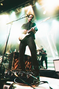 a man playing a guitar on stage