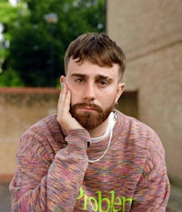 a man with a beard sitting on a bench