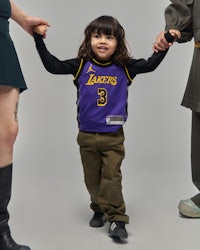 a little girl wearing a lakers jersey