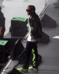 rapper lil wayne stands on stage at a music festival